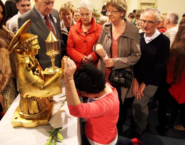 Bowing in religious worship before a statue of gold and a piece of flesh. 