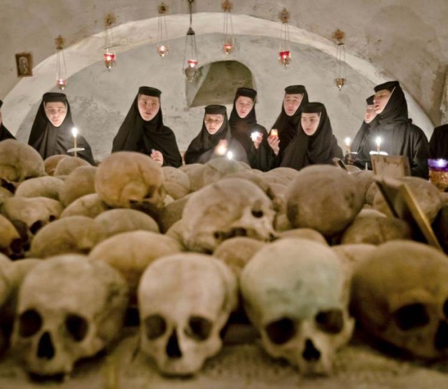 The nuns watch the cut of skulls. They might be the remains of Protestant martyrs. 